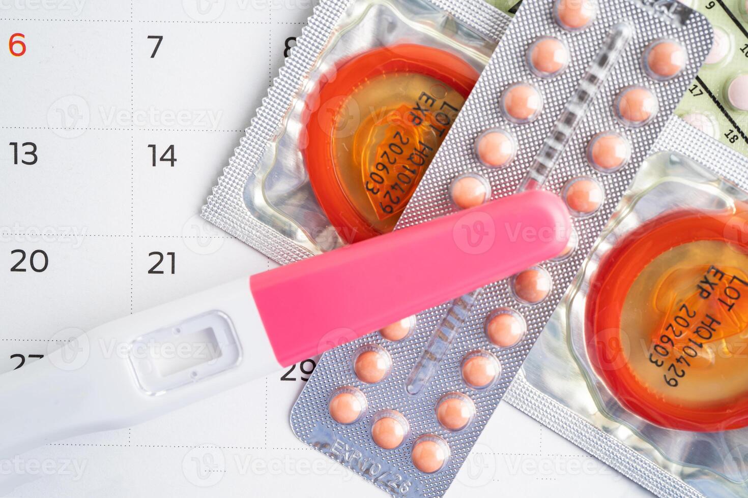 Pregnancy test and birth control pills on calendar, contraception health and medicine. photo