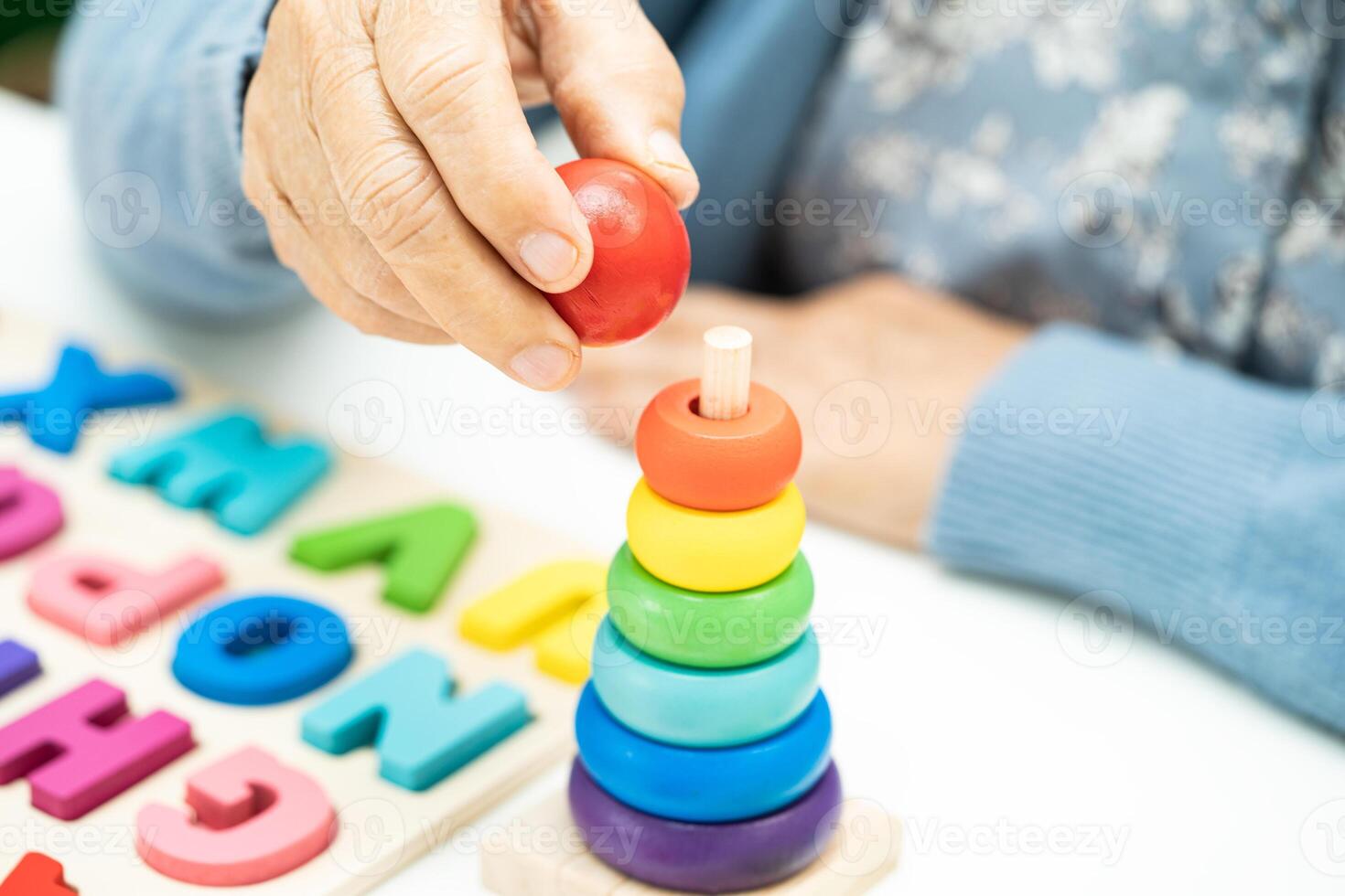 Alzheimer disease AD, Asian elderly woman patient suffering from dementia learn practical motor skills rehabilitation. photo