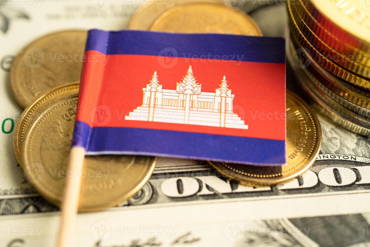 Stack of coins with Cambodia flag and US dollar banknotes. photo