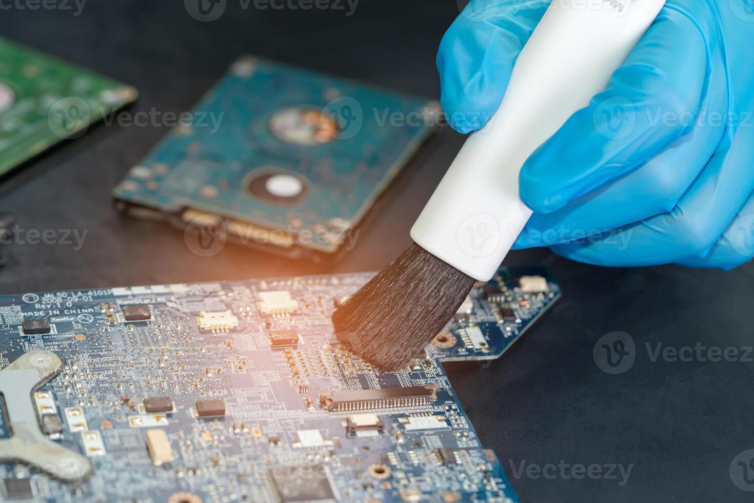 Asian technician repair and cleaning dirty micro circuit main board of smartphone electronic technology with brush, hardware, mobile phone, upgrade concept. photo