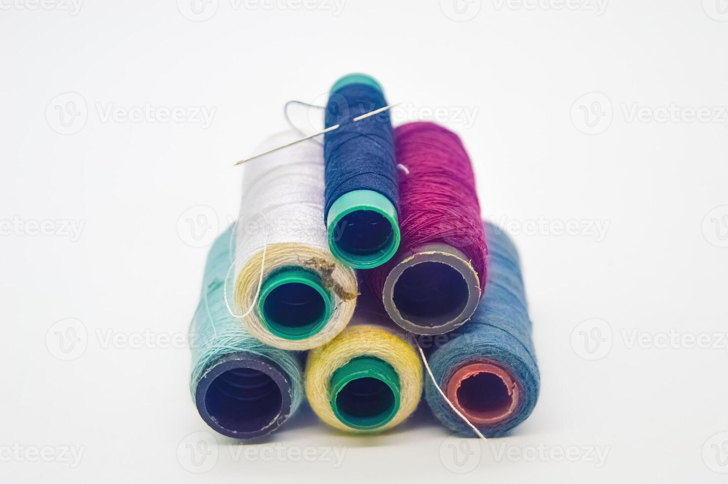 pile of rolls of colorful sewing thread with copy space isolated on white background photo
