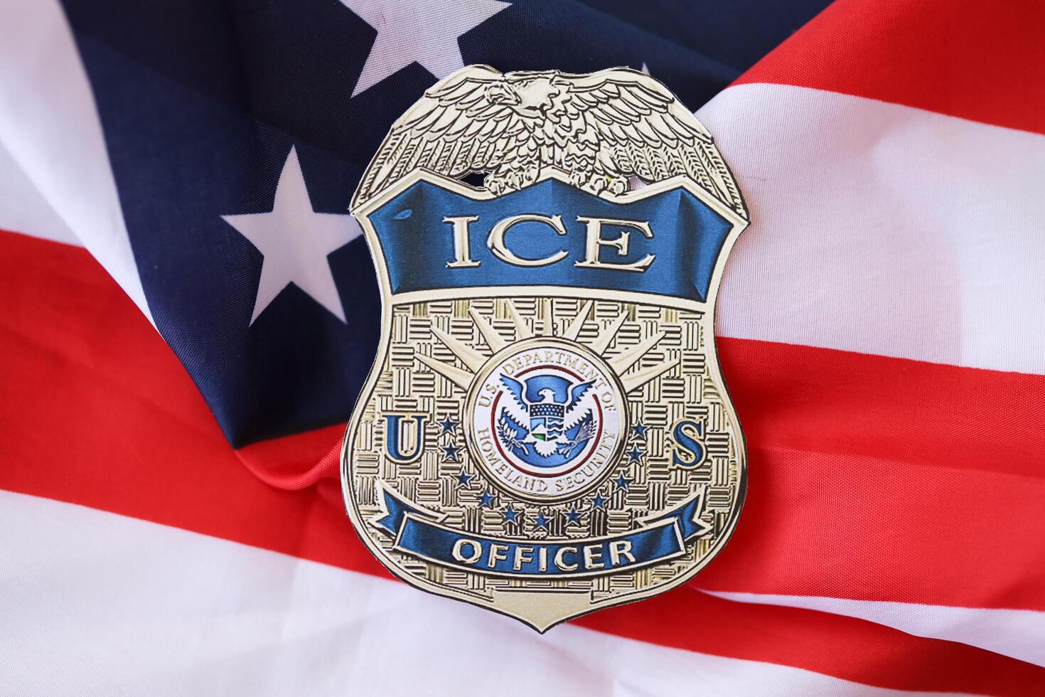 KYIV, UKRAINE - MARCH 9, 2024 US ICE Officer badge on United States of America flag photo