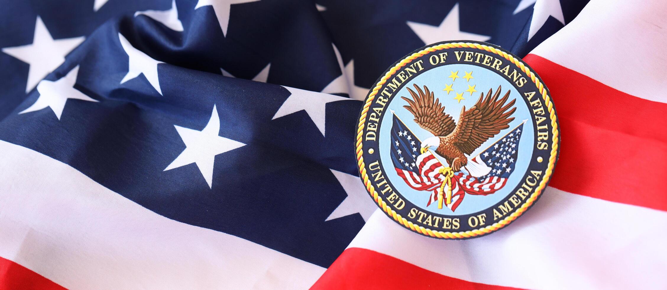 KYIV, UKRAINE - MARCH 9, 2024 US Department of Veteran Affairs seal on United States of America flag photo