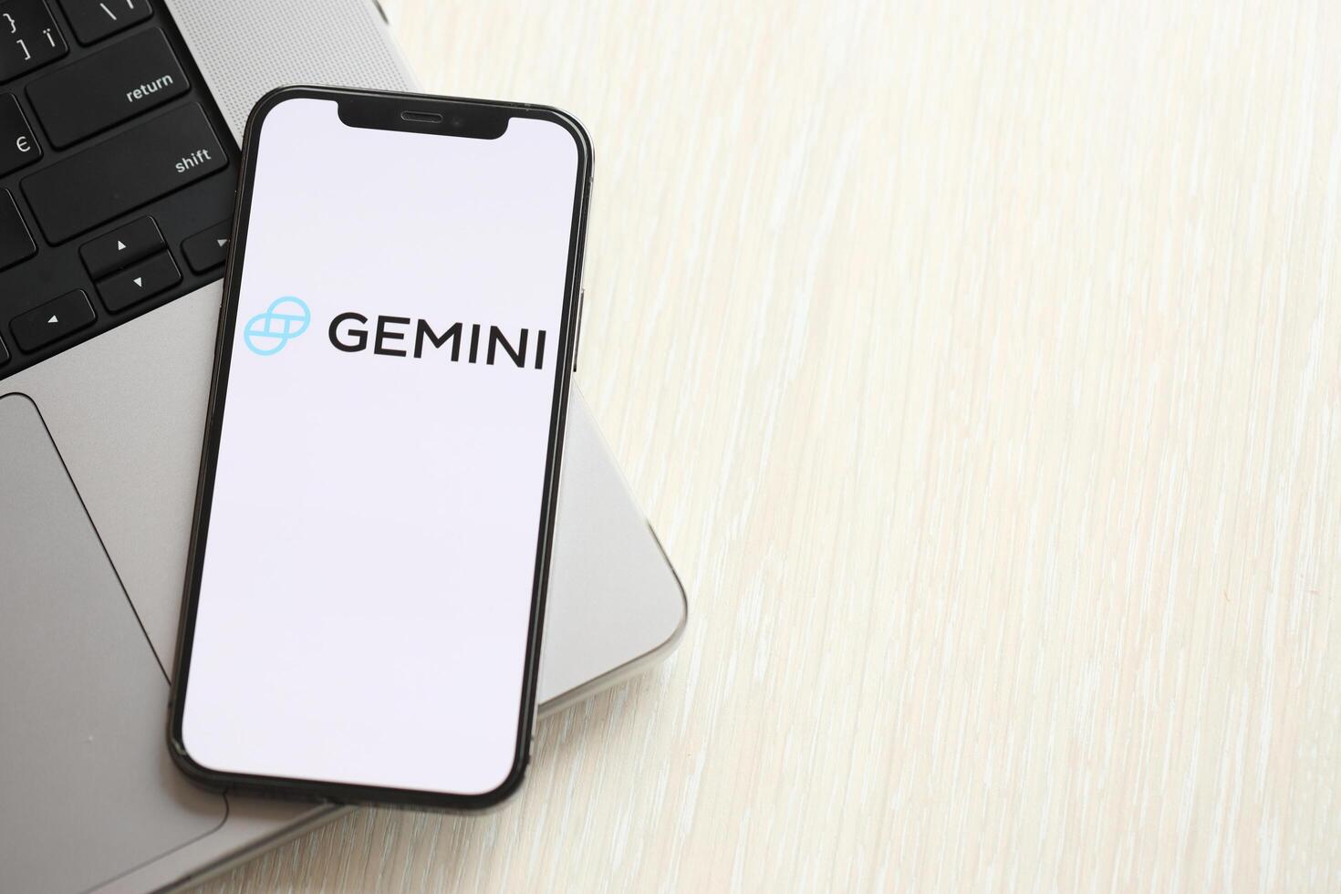 Kyiv, Ucrania - marzo 15, 2024 Geminis logo en iphone monitor pantalla en macbook panel logo en iphone monitor pantalla con dolares y bitcoins en macbook foto