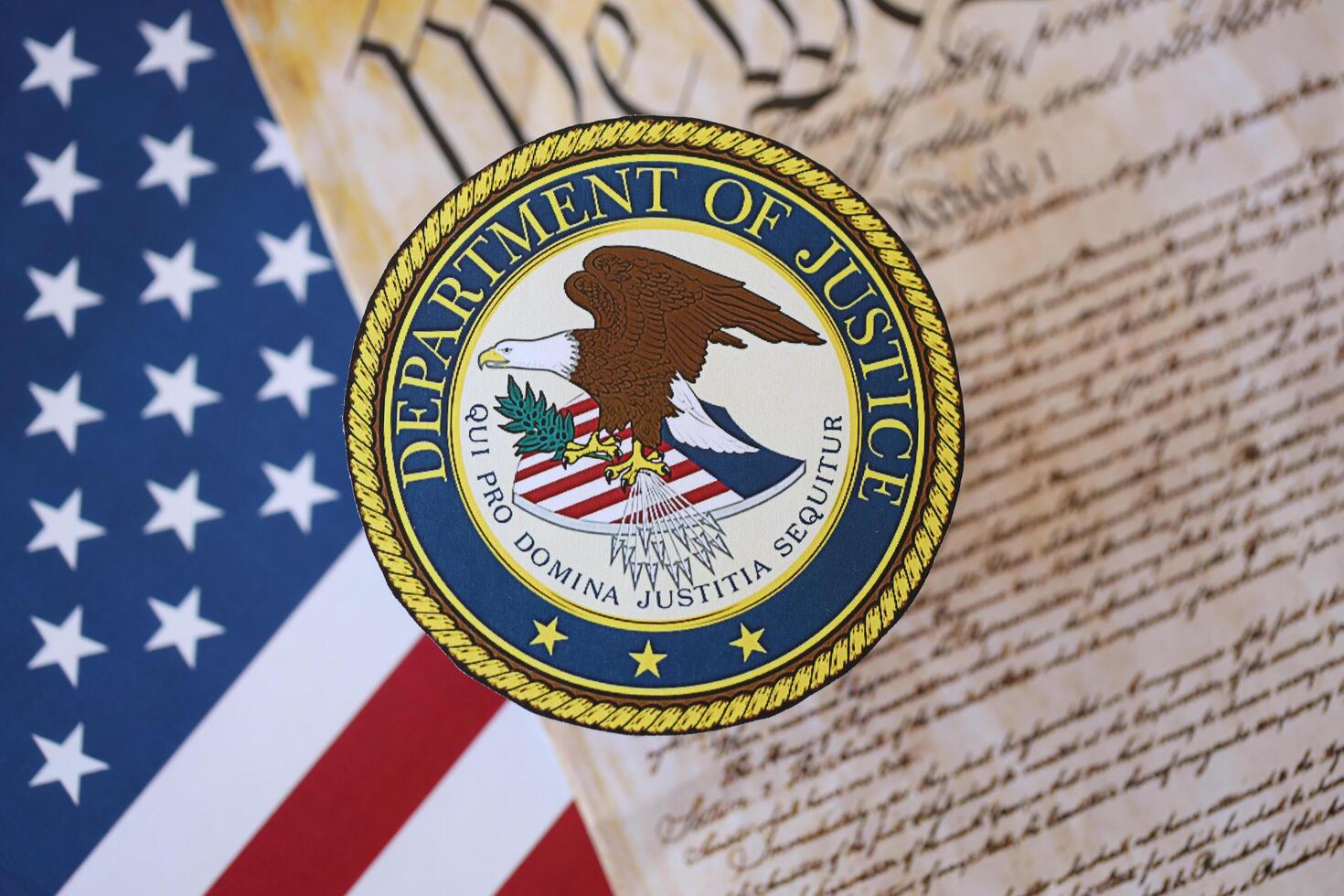 KYIV, UKRAINE - MARCH 9, 2024 US Department of Justice seal with United States Constitution on flag photo