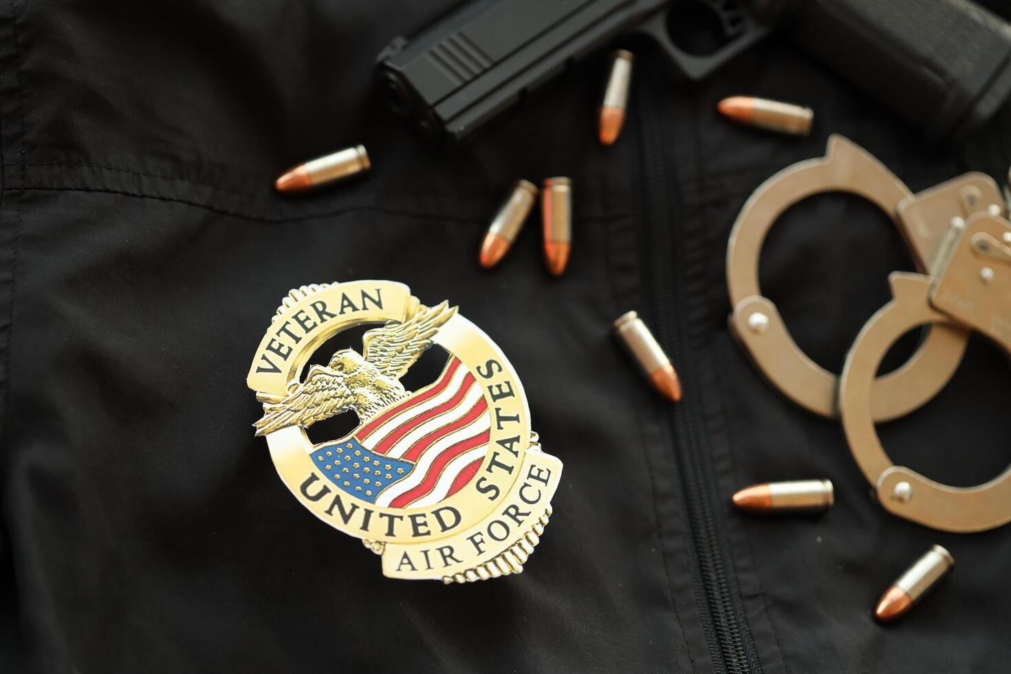 KYIV, UKRAINE - MARCH 9, 2024 US Air Force Veteran badge on black jacket uniform with gun, bullets and handcuffs photo