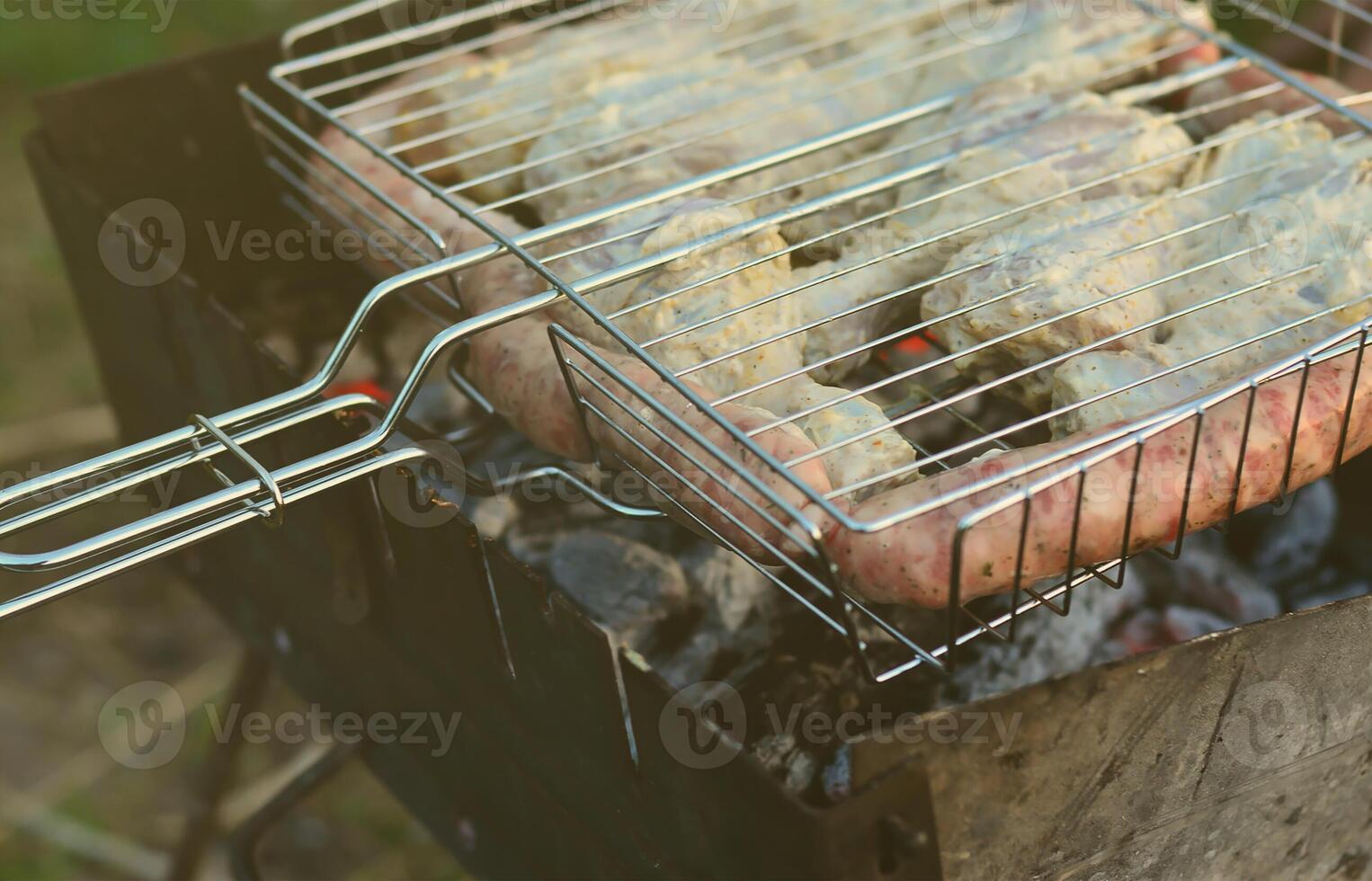 Shish kebabs from chicken wings are fried in the field. A classic barbecue in the open air. The process of frying meat on charcoal photo