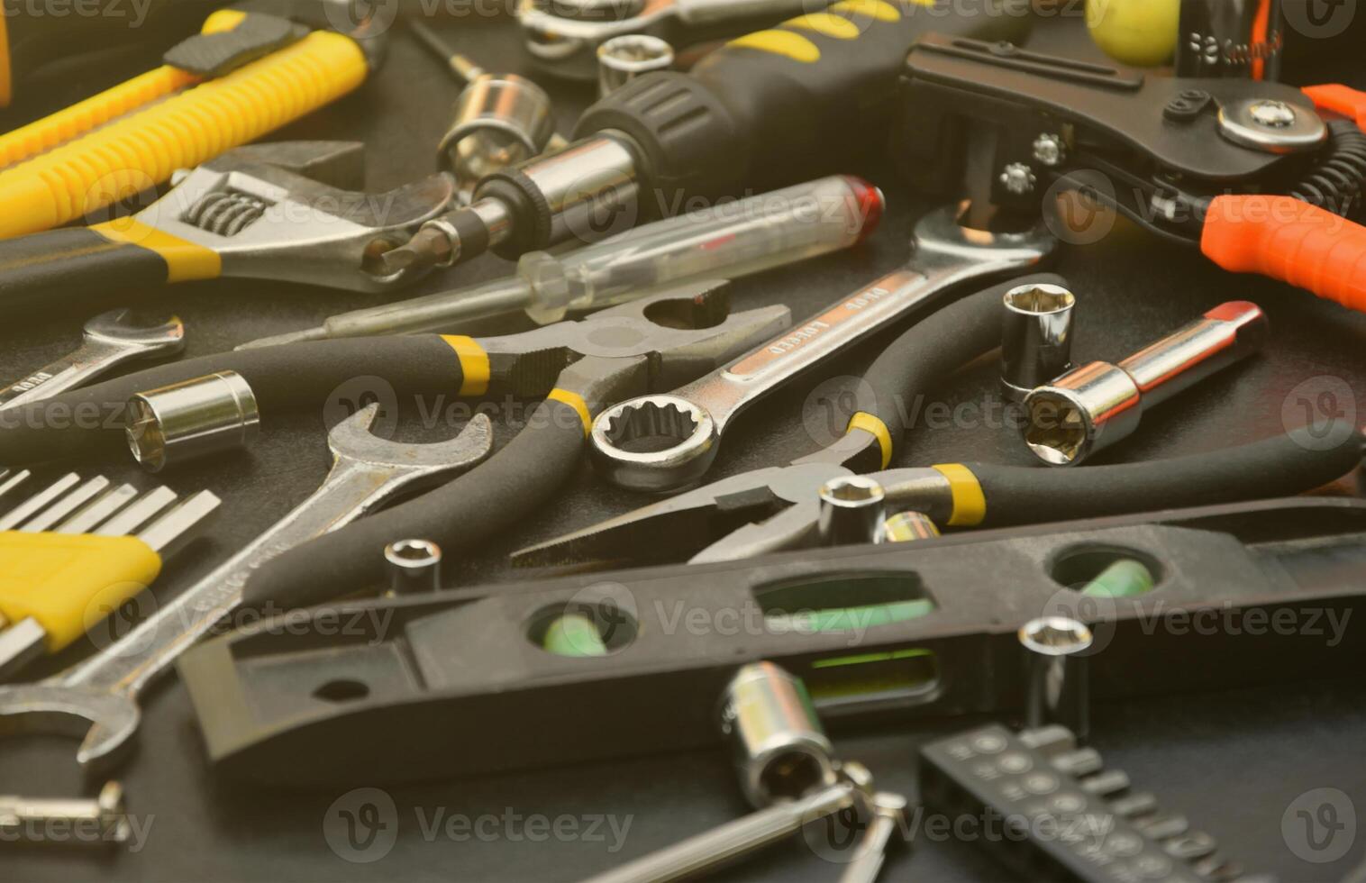 Handyman tool kit on black wooden table. Many wrenches and screwdrivers, pilers and other tools for any types of repair or construction works. Repairman tools photo