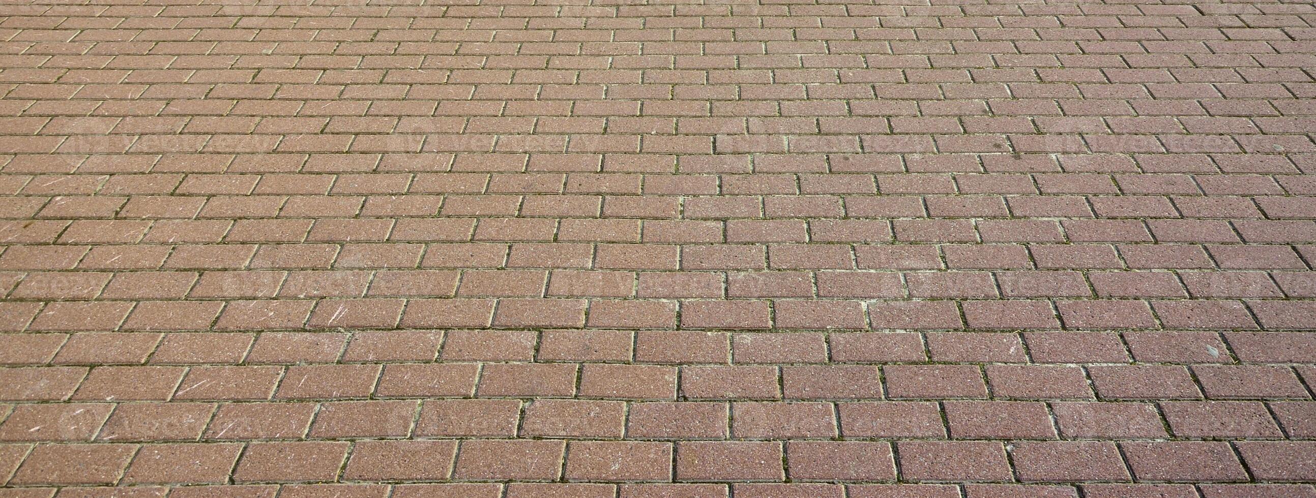 A large area, covered with a quality paving stone in daylight photo
