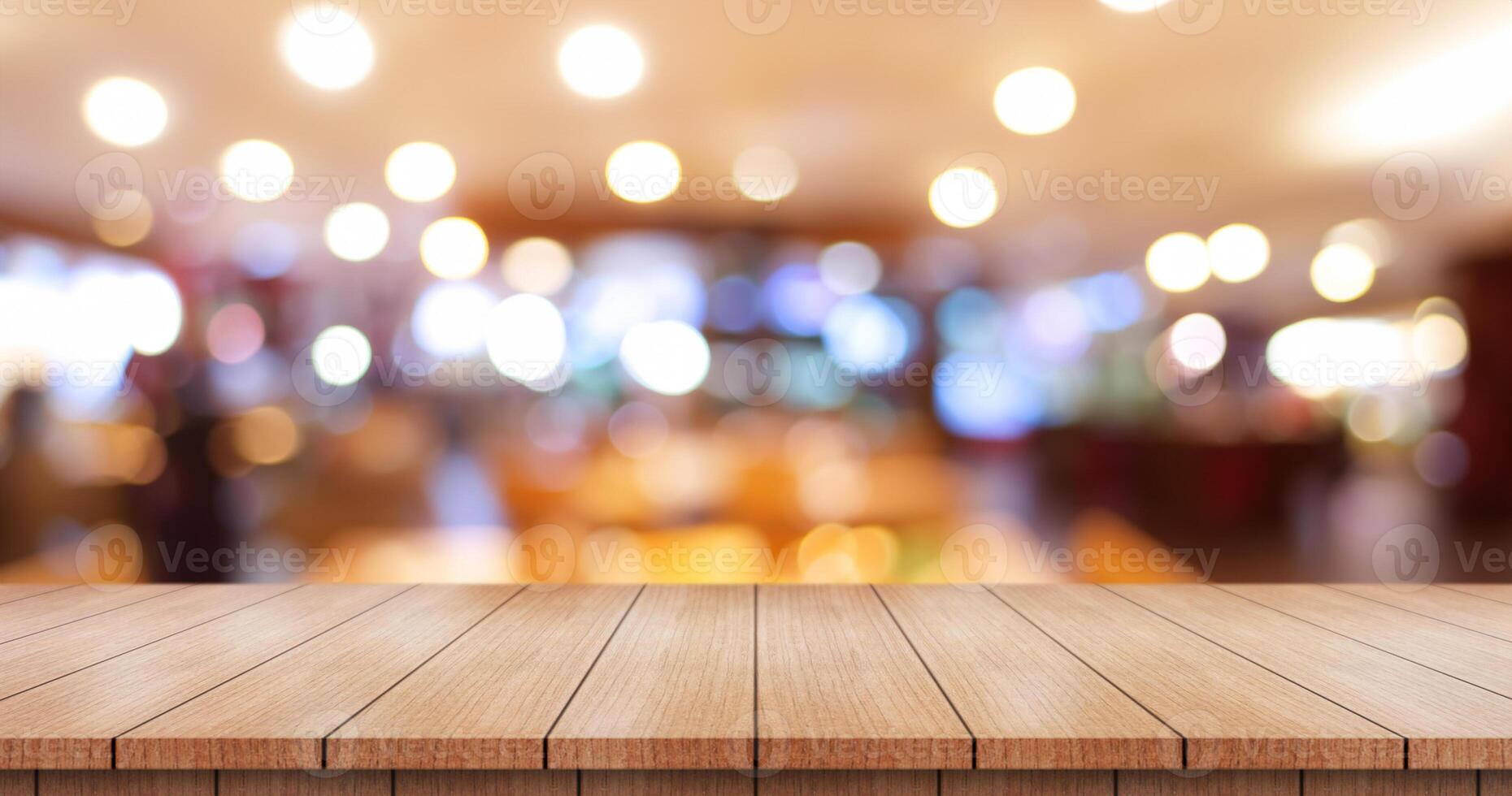 Empty wooden table top with lights bokeh on blur restaurant background. photo