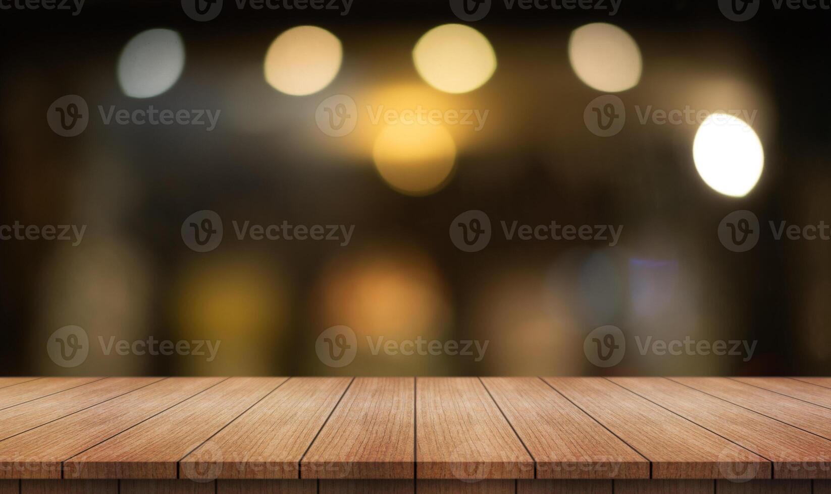 Empty wooden table top with lights bokeh on blur restaurant background. photo