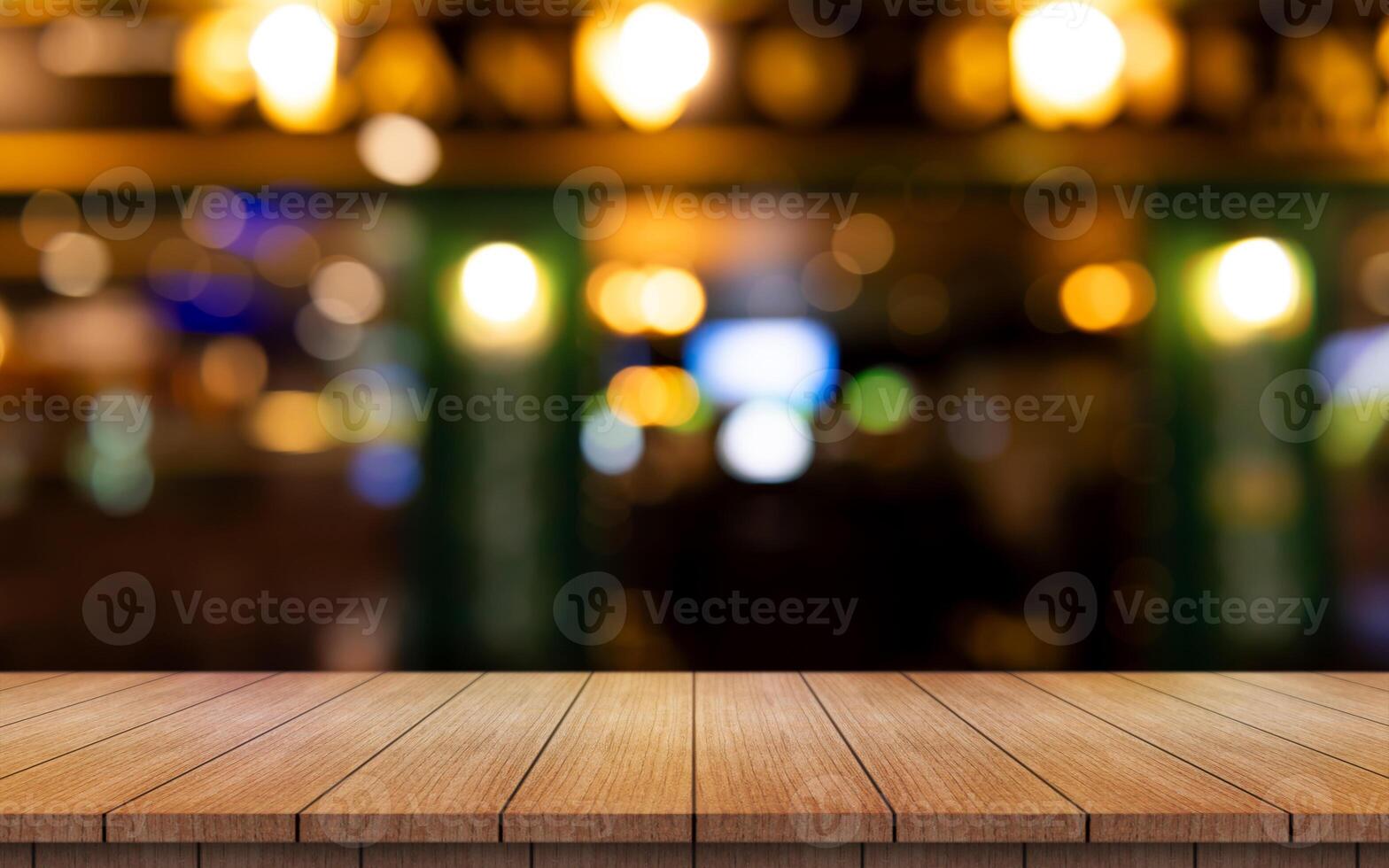 Empty wooden table top with lights bokeh on blur restaurant background. photo
