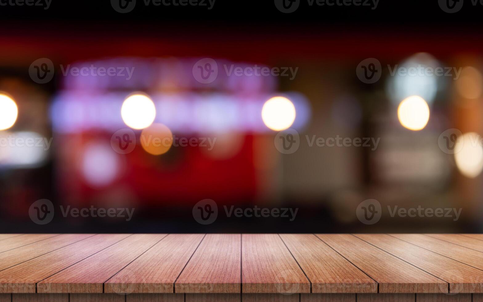 vacío de madera mesa parte superior con luces bokeh en difuminar restaurante antecedentes. foto