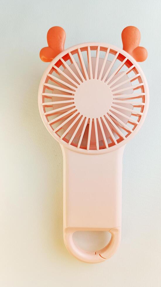 Pink portable mini fan on white background photo