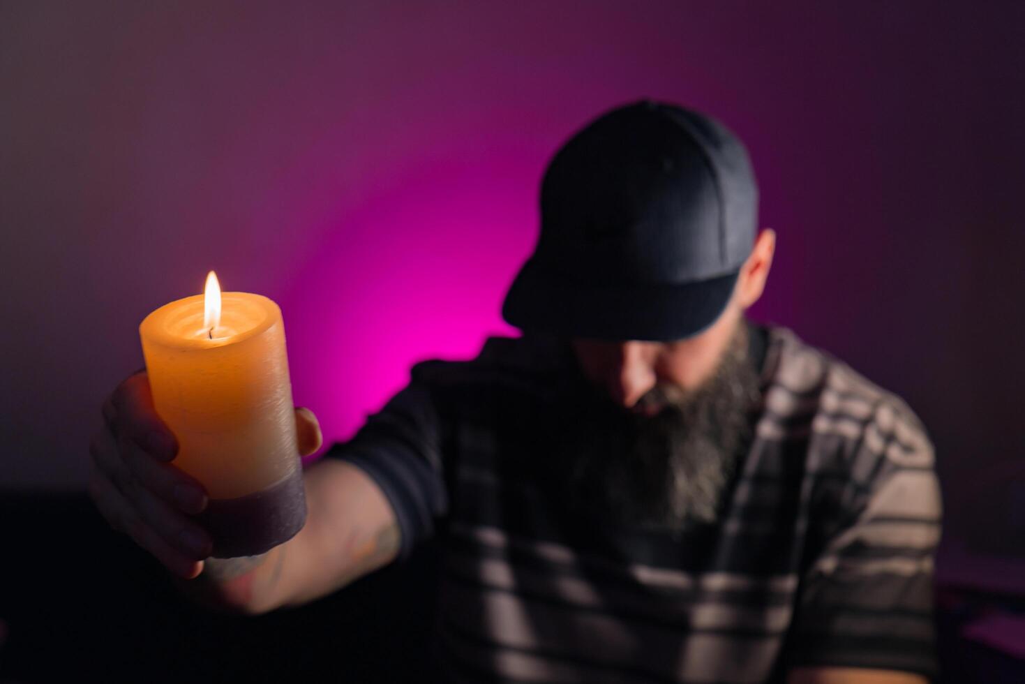 Bearded man holding a lit candle in his hand photo