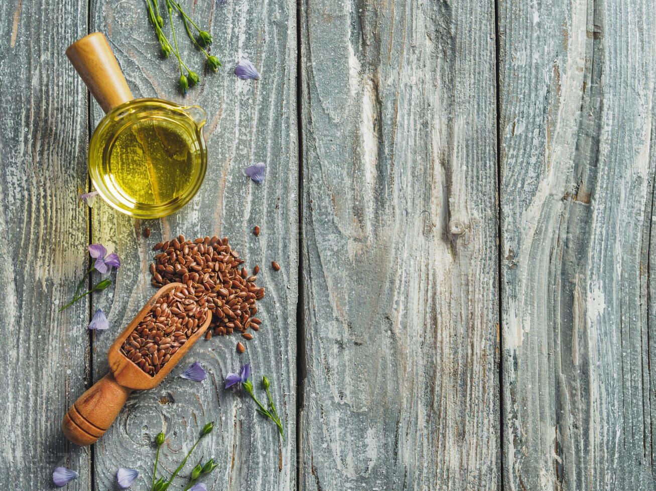 Flax seeds and flax oil. Brown linen seeds and flaxseed oil on old gray wooden background. Copy space. Top view or flat lay. photo