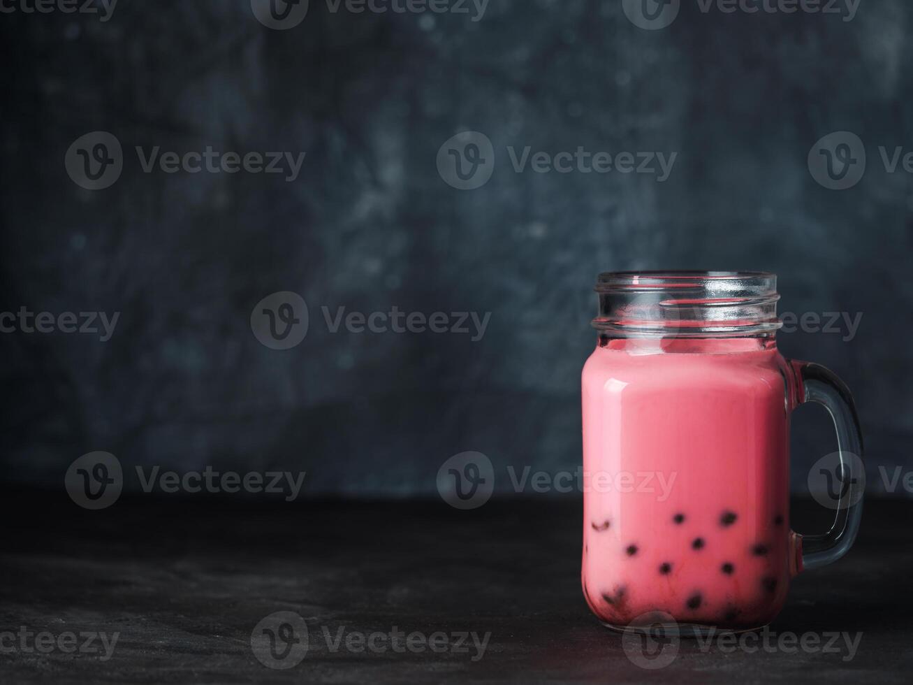 Homemade Milk Bubble Tea with Tapioca Pearls balls. Popular Taiwan bubble tea in glass mason jar with copy space for text. Bubble tea on dark background. photo