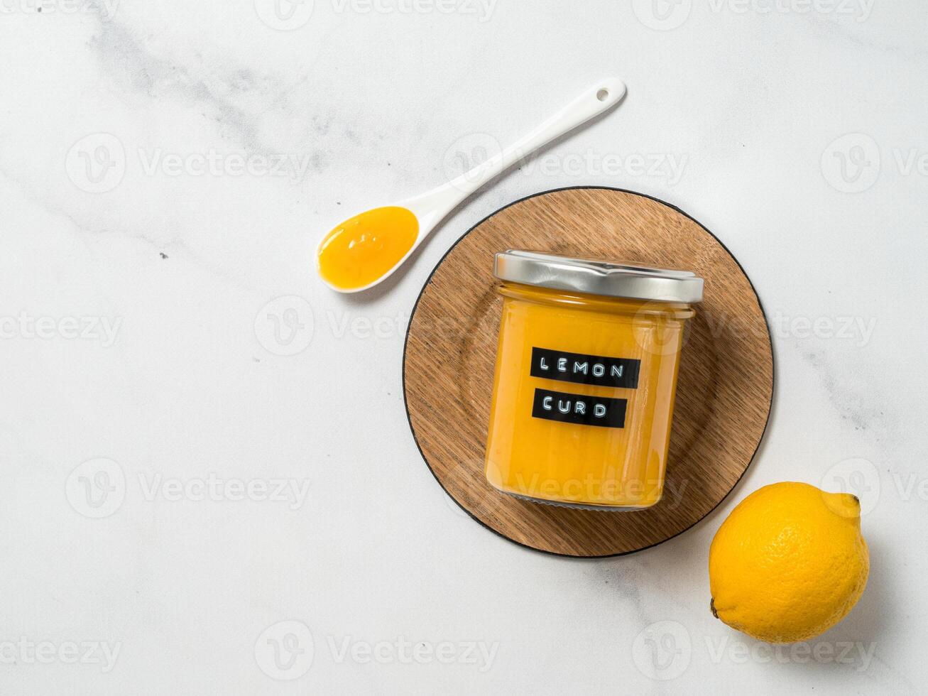 Homemade lemon curd in jar, top view, vertical photo