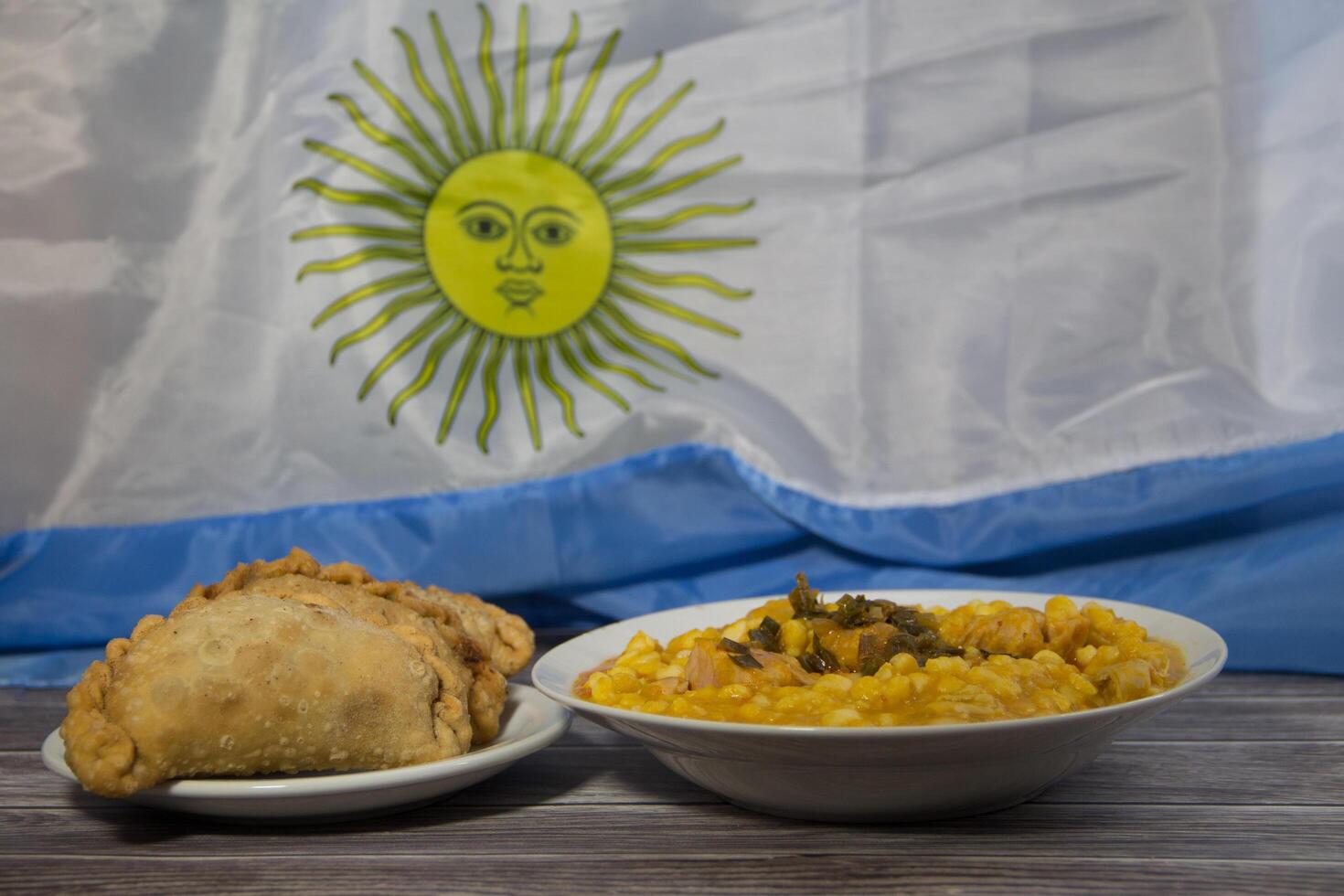 plate of locro and empanadas with the Argentine flag, traditional patriotic food photo