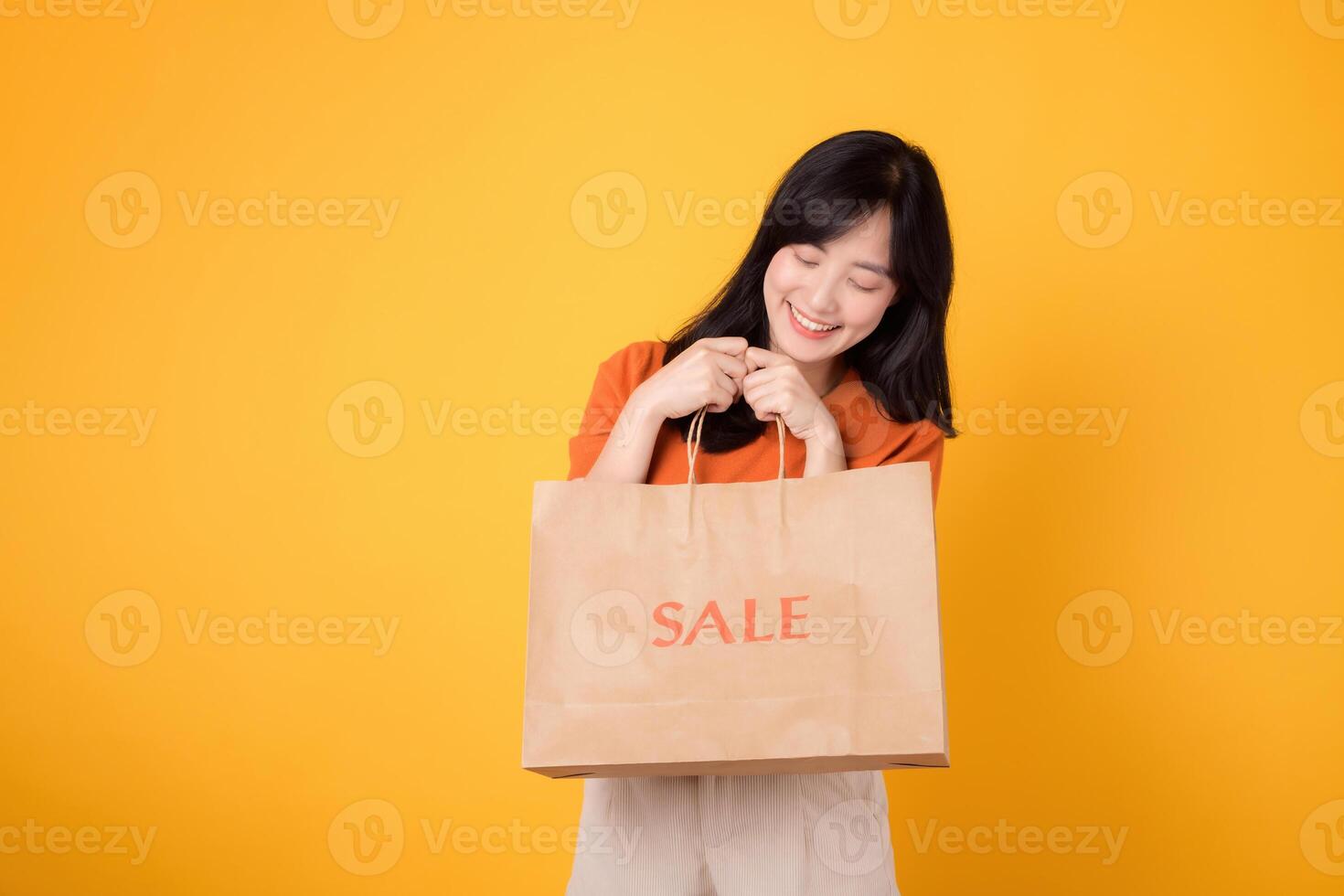 Uncover the thrill of surprising deals and joyful shopping. Young woman in her 30s presents her purchases, capturing the excitement of the best bargains. photo