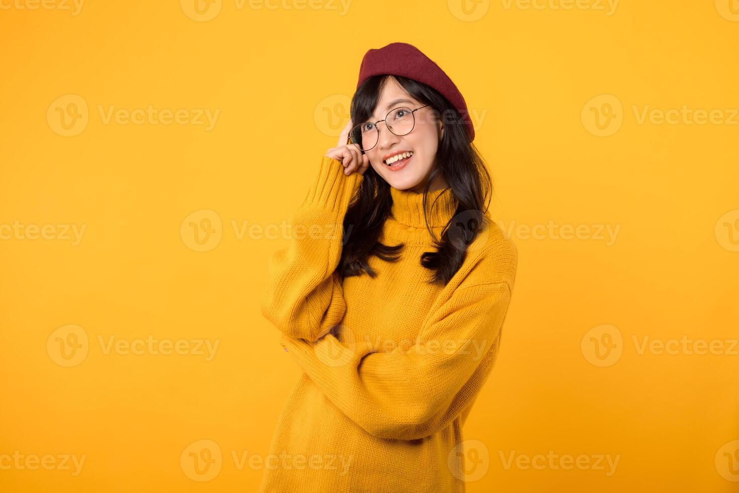 portrait attractive young 30s Asian woman beautiful model in artist look wearing yellow sweater and red hat isolated on yellow background. Thinking gesture body language concept. photo