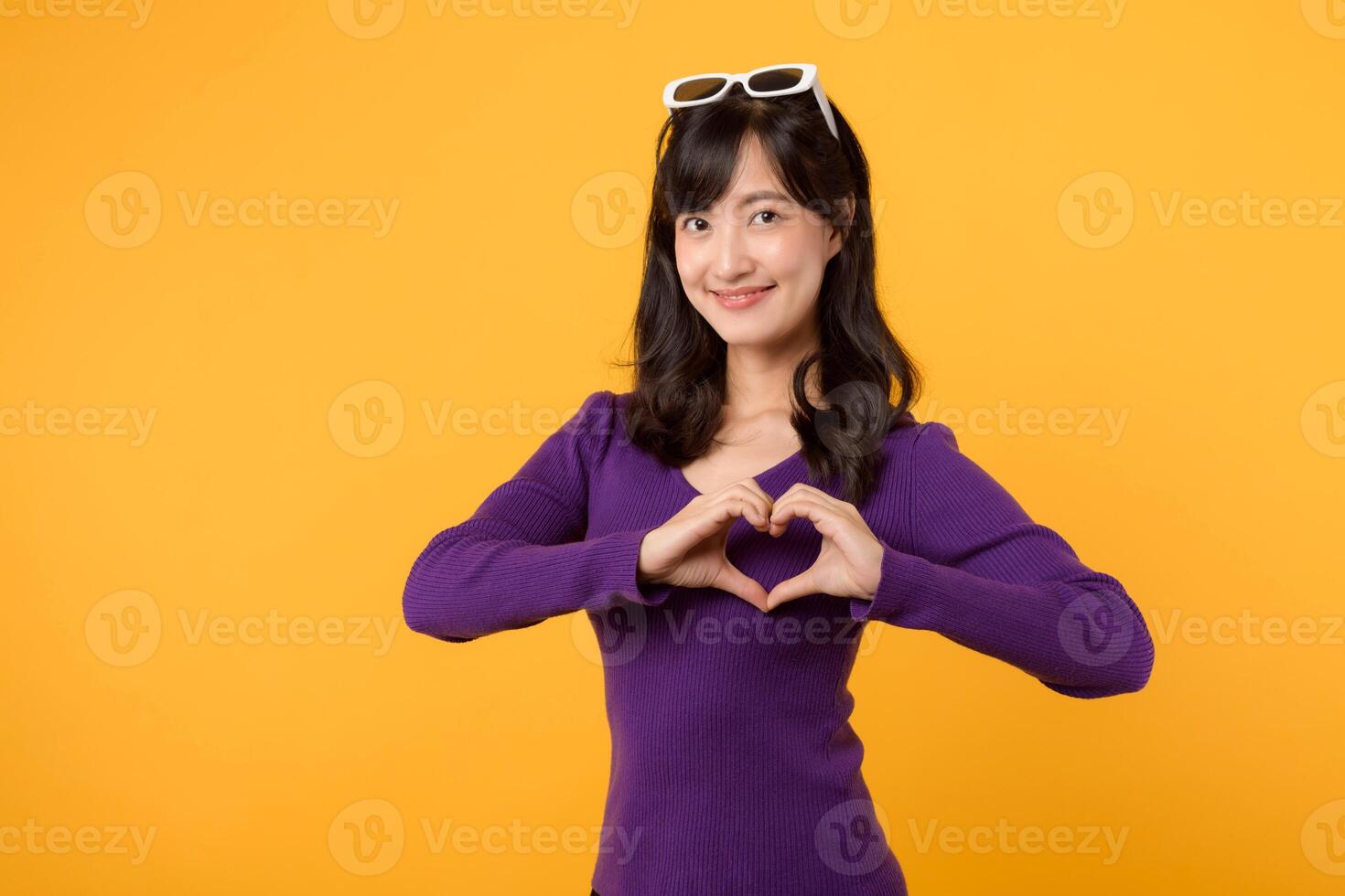Celebrating Valentine's Day with joy, a young lady in a purple sweater sends a loving hand gesture, radiating positivity and romantic emotions. photo