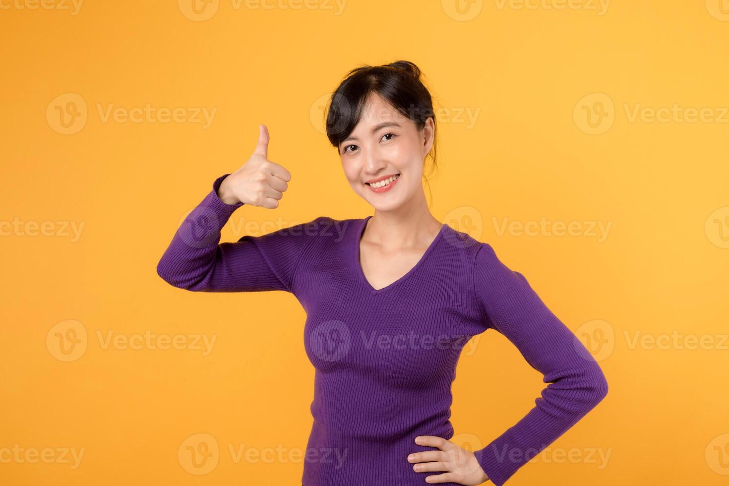 Positive and successful young woman 30s flashing a thumbs-up sign with a cheerful smile. A portrait of confidence and happiness. photo