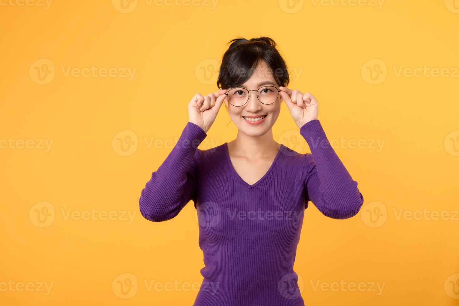 retrato de joven 30s asiático mujer vistiendo púrpura camisa, empresa trabajador en los anteojos, sonriente, en pie terminado amarillo antecedentes foto