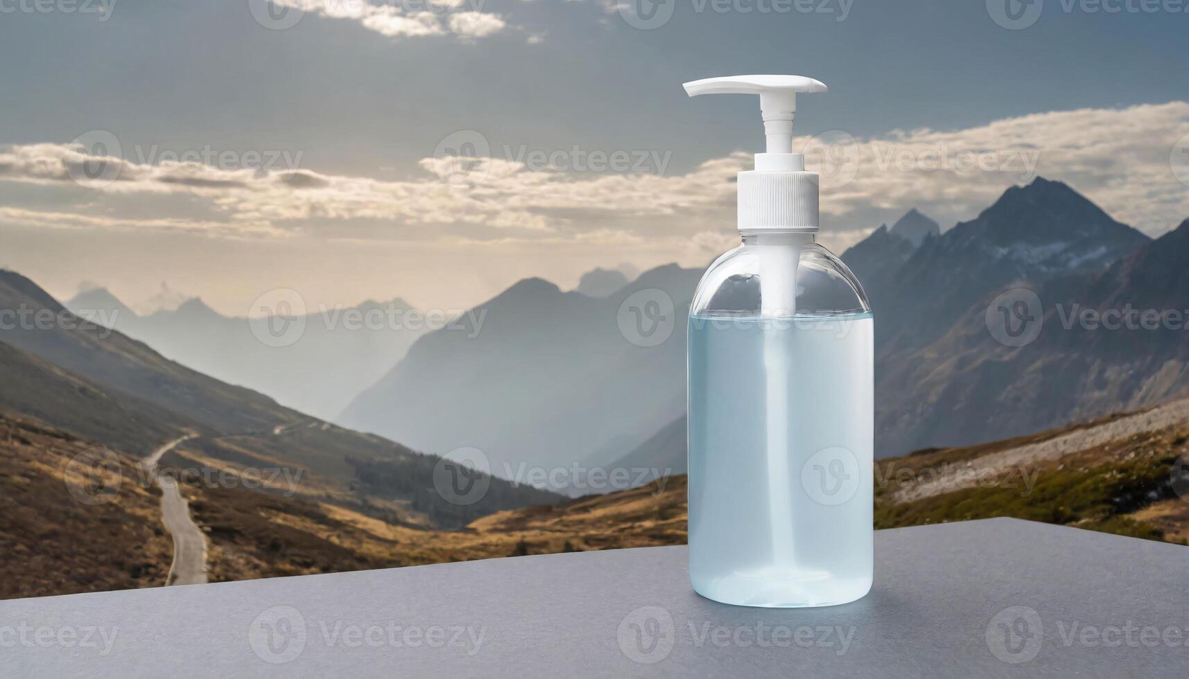 a bottle of hand sanitizer on a table in front of a mountain range photo