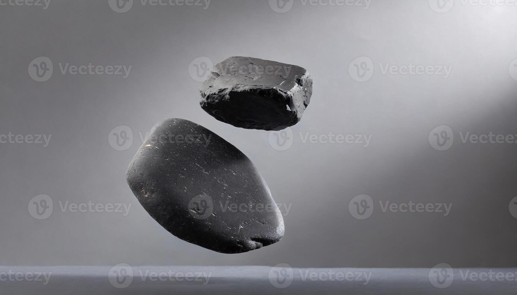 two rocks are floating in the air on a gray surface photo