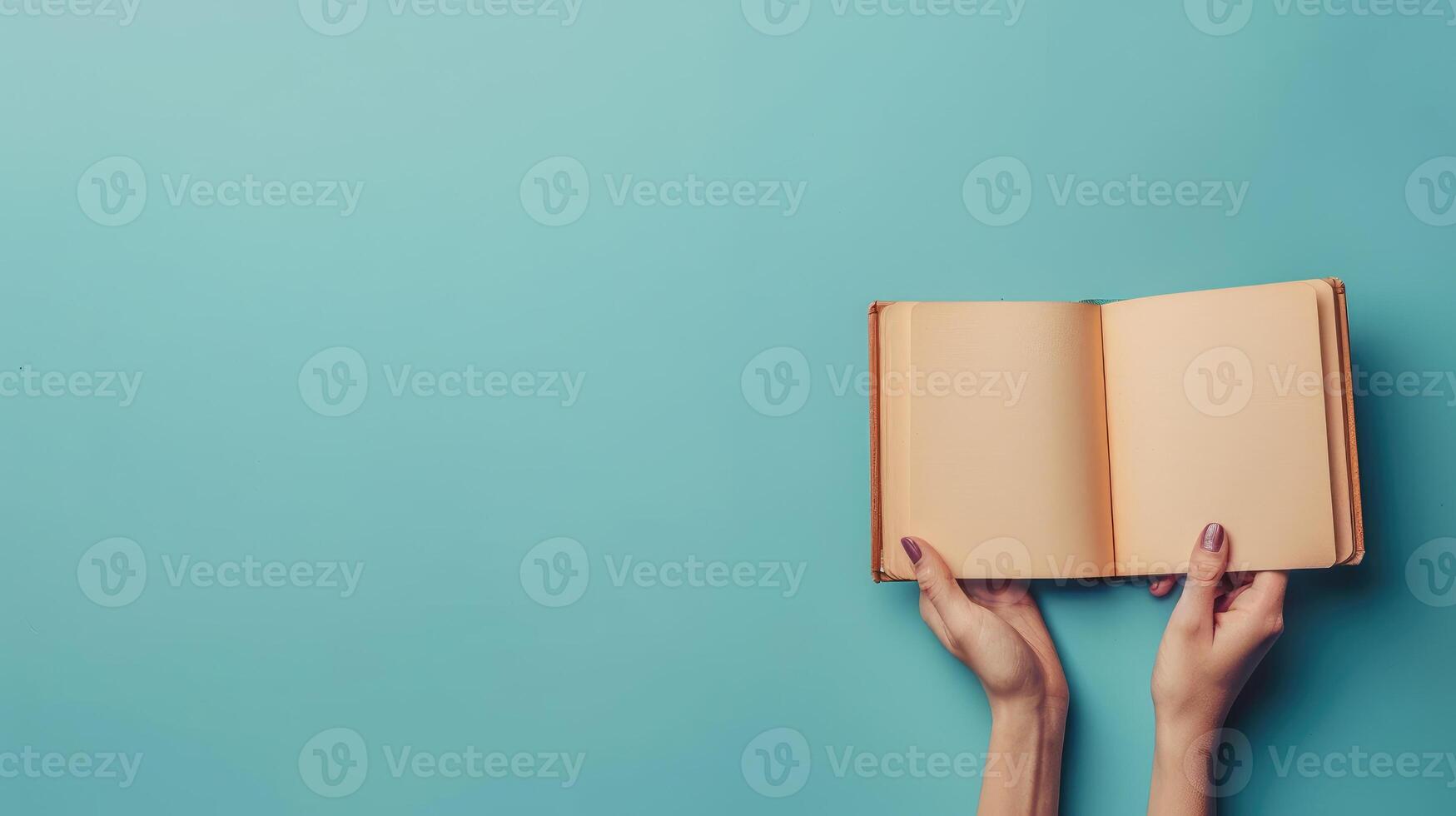 Woman hands with open empty book at light blue background. Top view. Space for text. Blank paper album mockup. photo