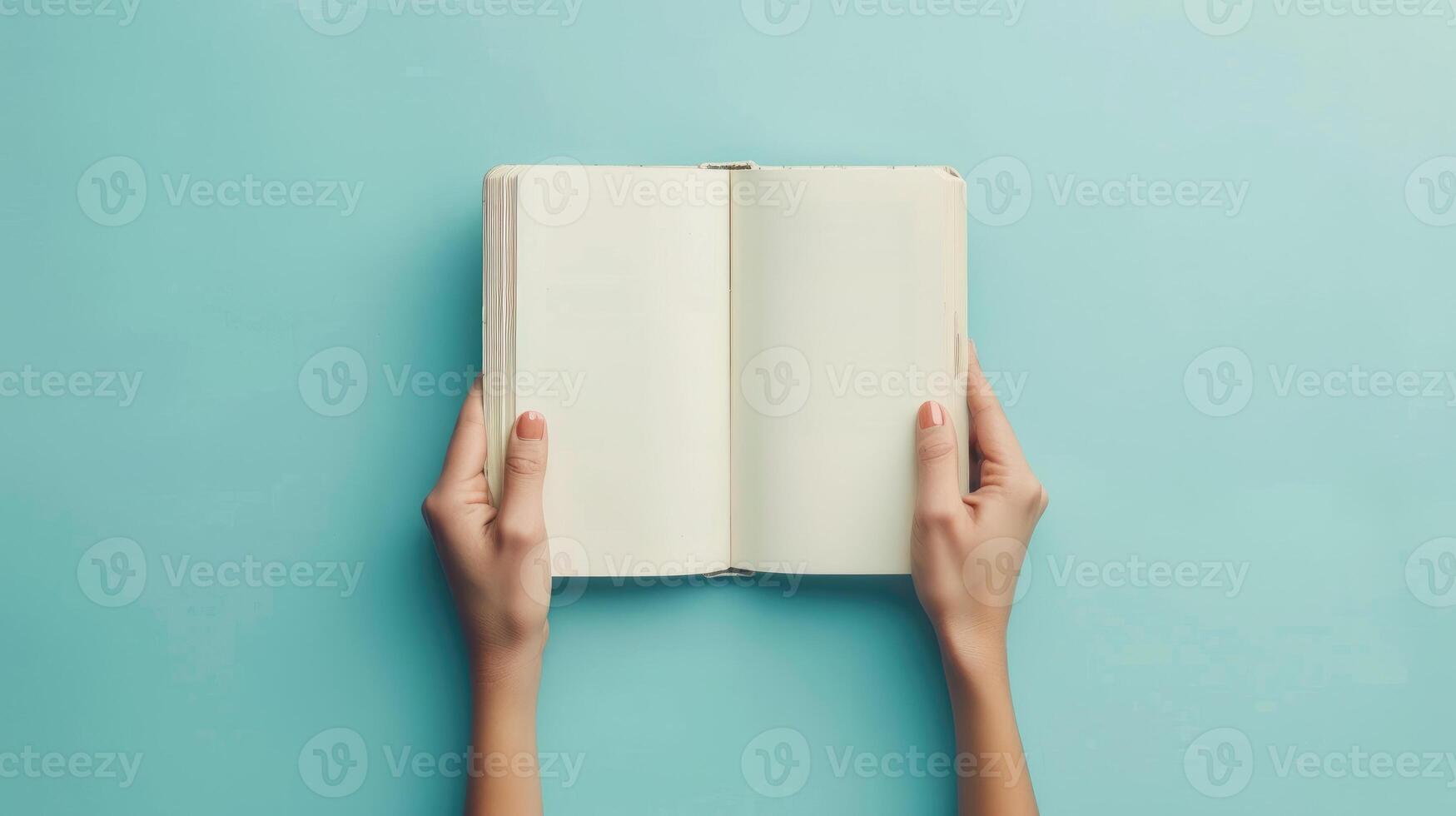 Woman hands with open empty book at light blue background. Top view. Space for text. Blank paper album mockup. photo
