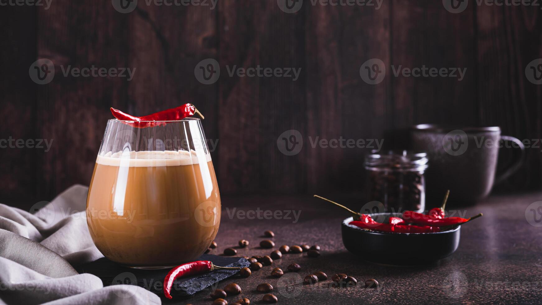 Spicy coffee latte with chili pepper in a glass on the table web banner photo