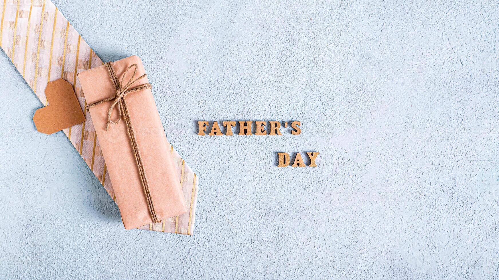 Father's day gift on tie, cardboard heart and inscription on blue background web banner photo