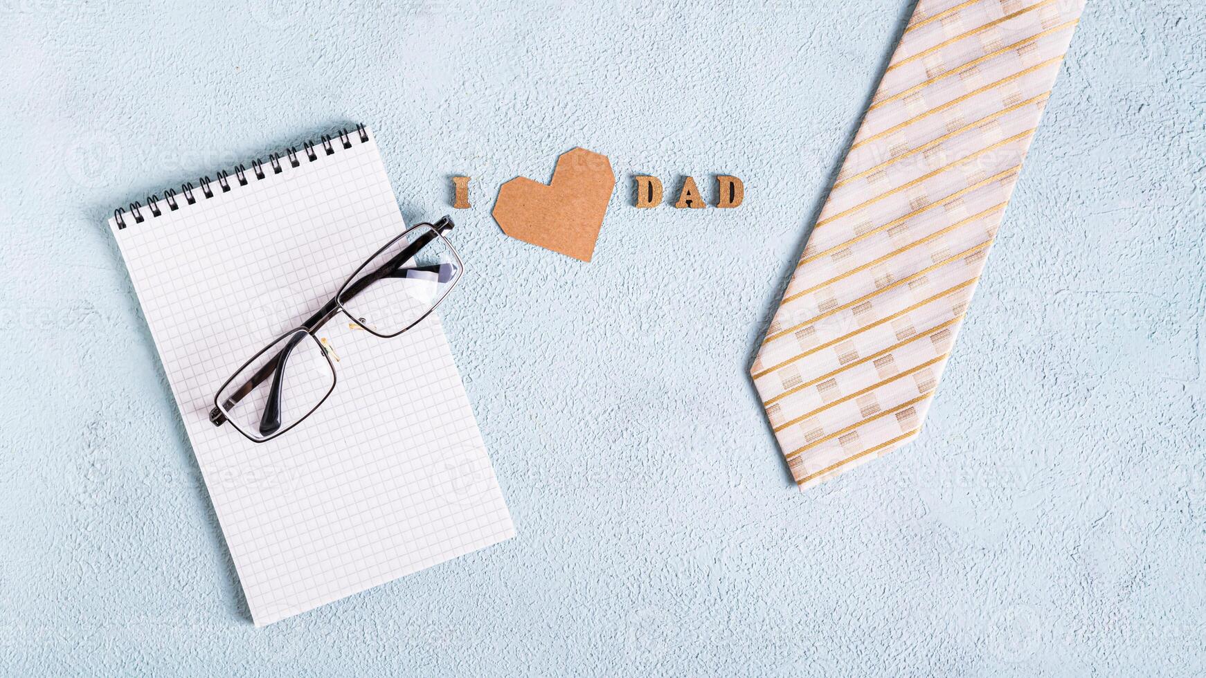 Father's day notebook, glasses, tie and inscription on blue background photo