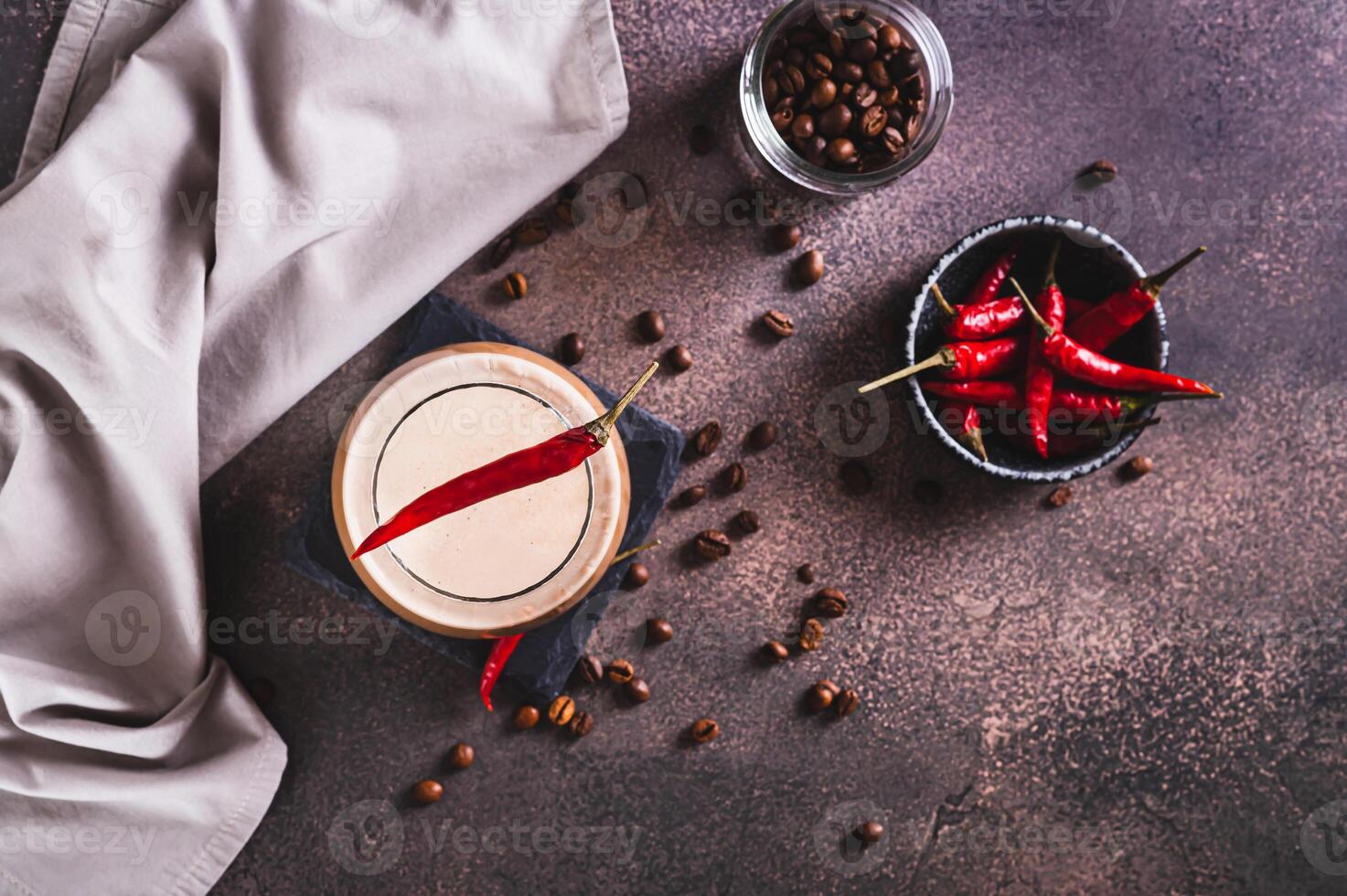 Spicy coffee latte with chili pepper in a glass on the table top view photo