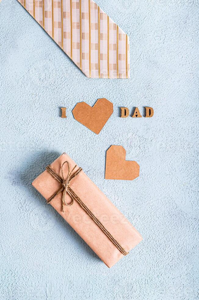Father's day craft gift, tie, heart and inscription on a blue background vertical view photo