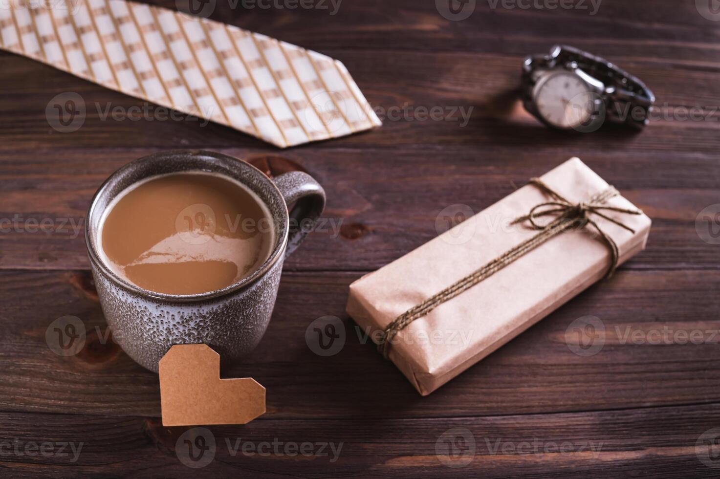 Father's day coffee mug, cardboard heart, gift, tie and watch on wooden table photo