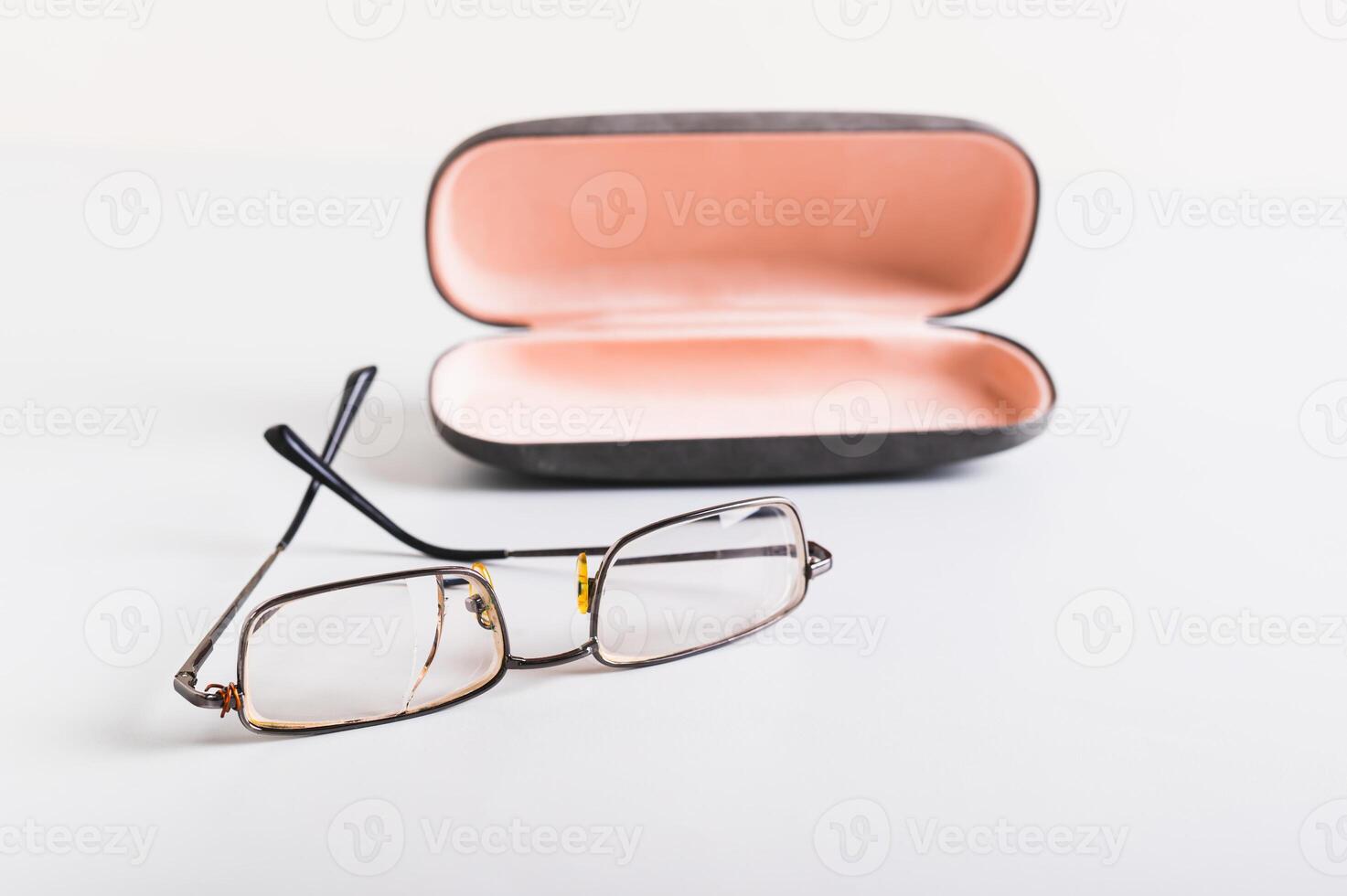 Concept of improper storage of old broken glasses on the background of a hard case on the table photo