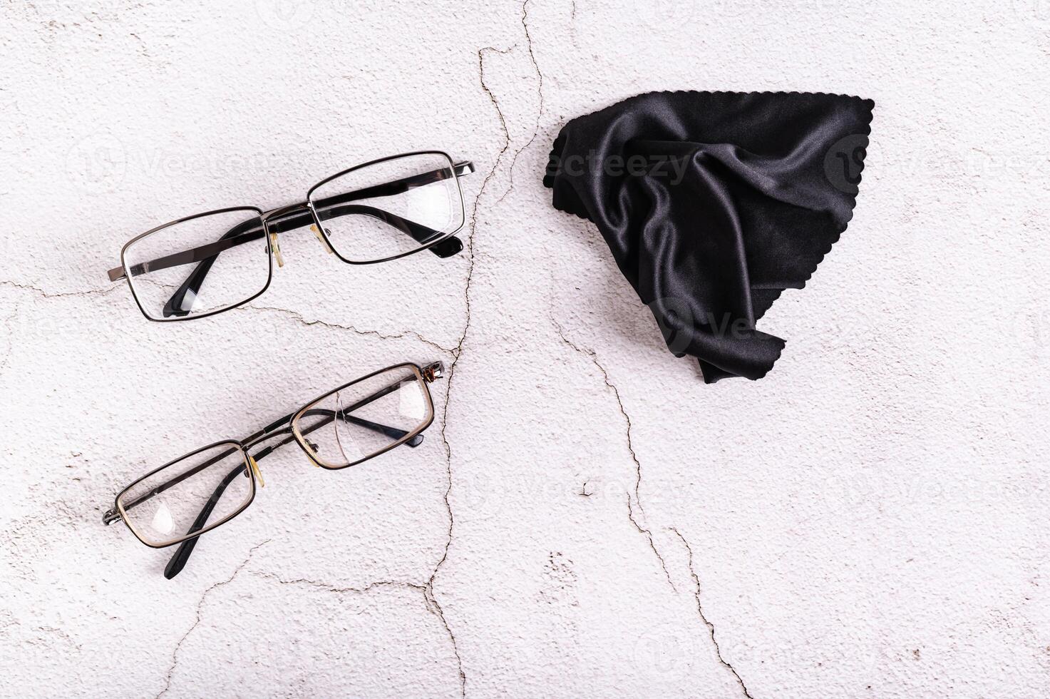 Whole glasses, broken glasses and cleaning cloth on a gray background top view photo