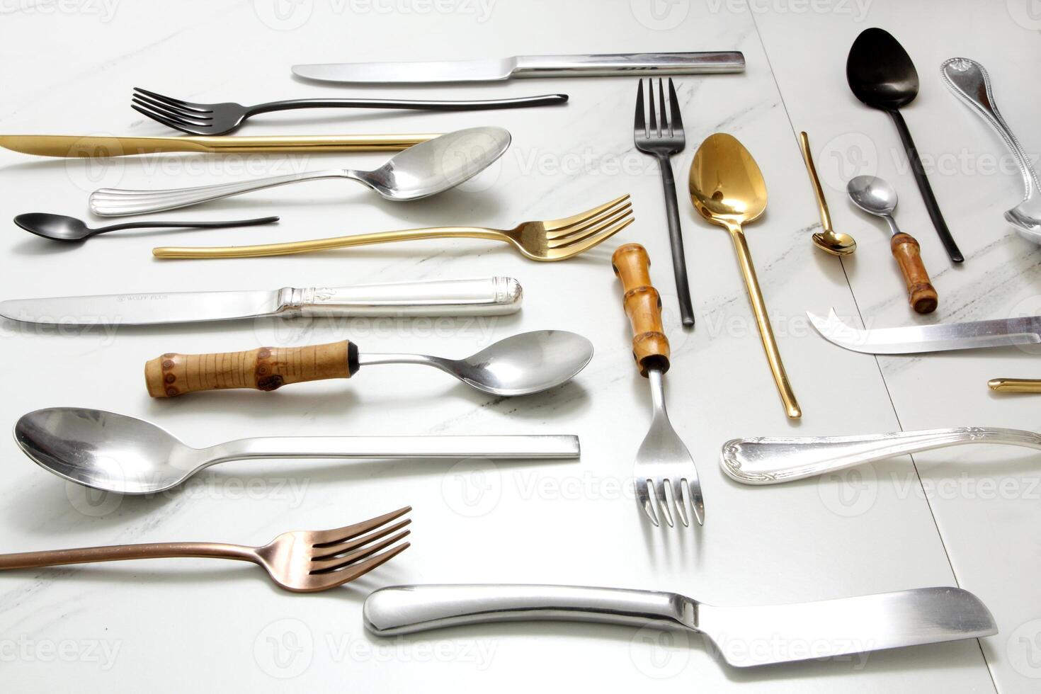 knives, cutlery, spoons and forks on a marble background photo