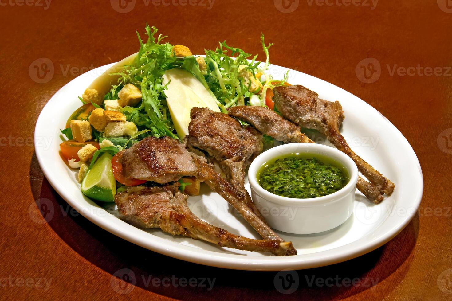 grilled lamb with salad and sauce on plate photo