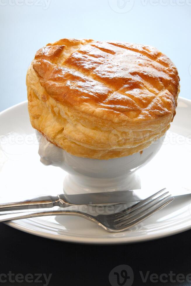 Onion soup with puff pastry crust photo