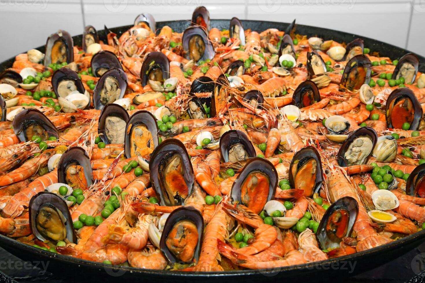 Paella, classic Spanish dish with rice, vegetables and seafood photo