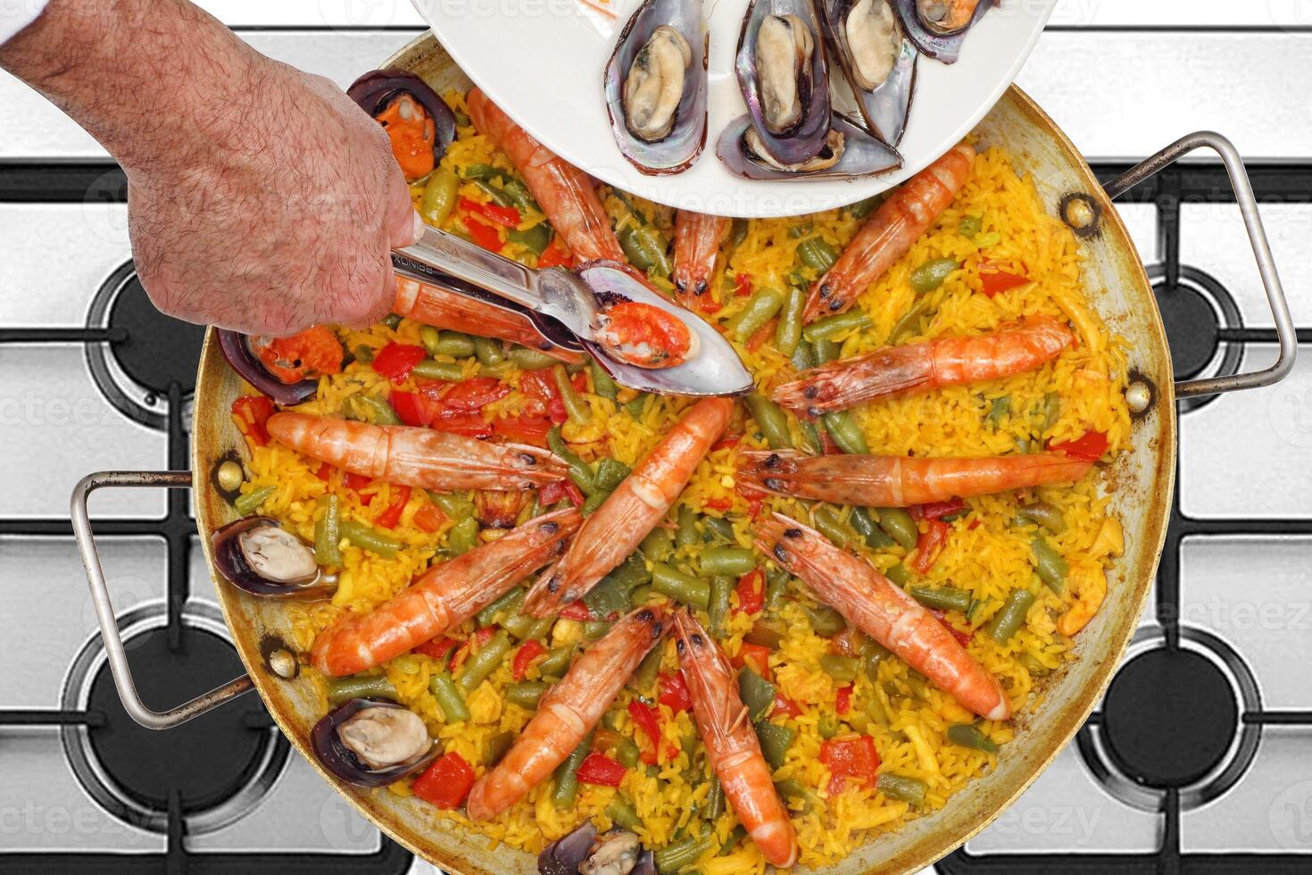 step-by-step guide to making Paella Valenciana, a classic Spanish dish with seafood and saffron rice photo