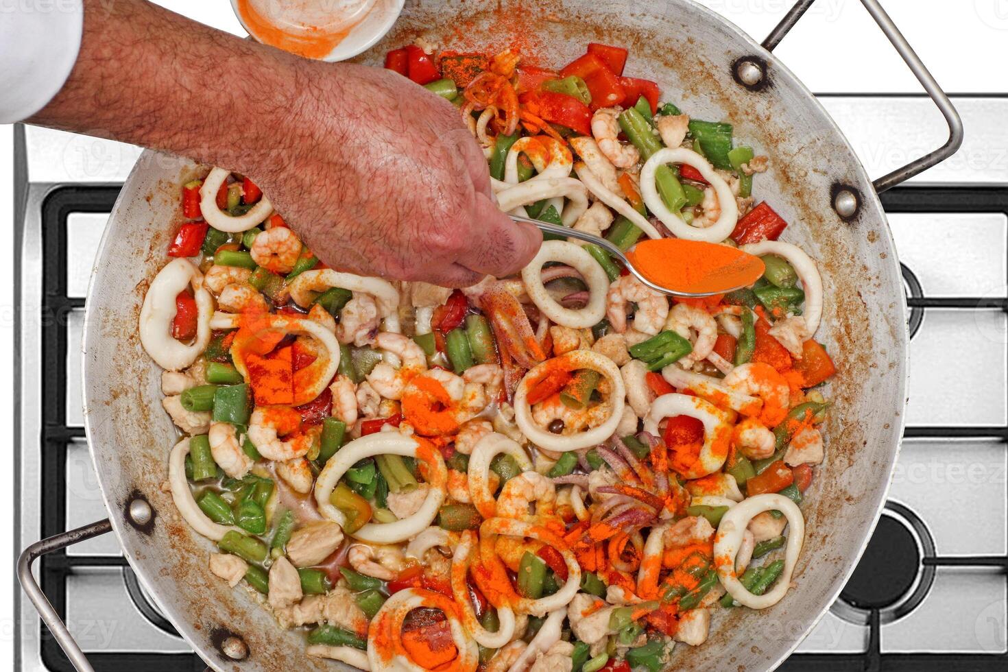 step-by-step guide to making Paella Valenciana, a classic Spanish dish with seafood and saffron rice photo