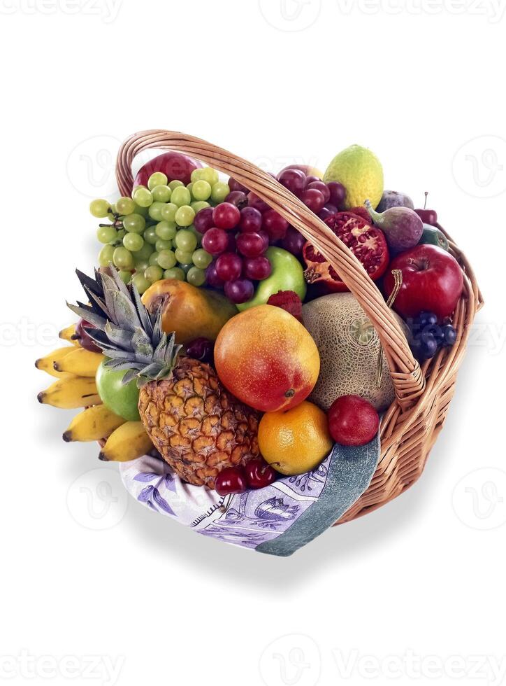 basket with grapes, orange, pineapple, mango, bananas and other fruits on white background photo