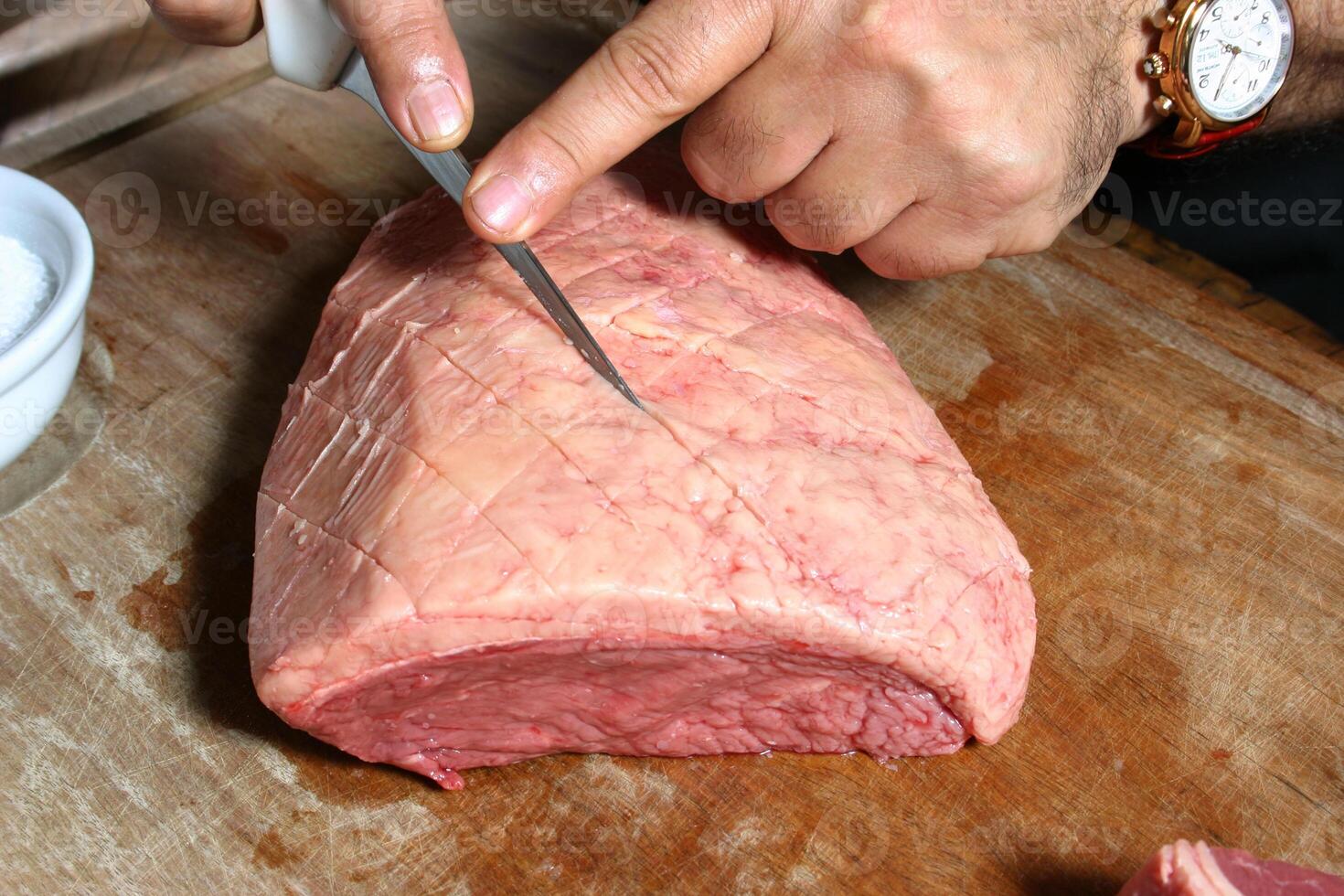 professional butcher teaching step by step how to prepare picanha, a Brazilian cut of meat photo