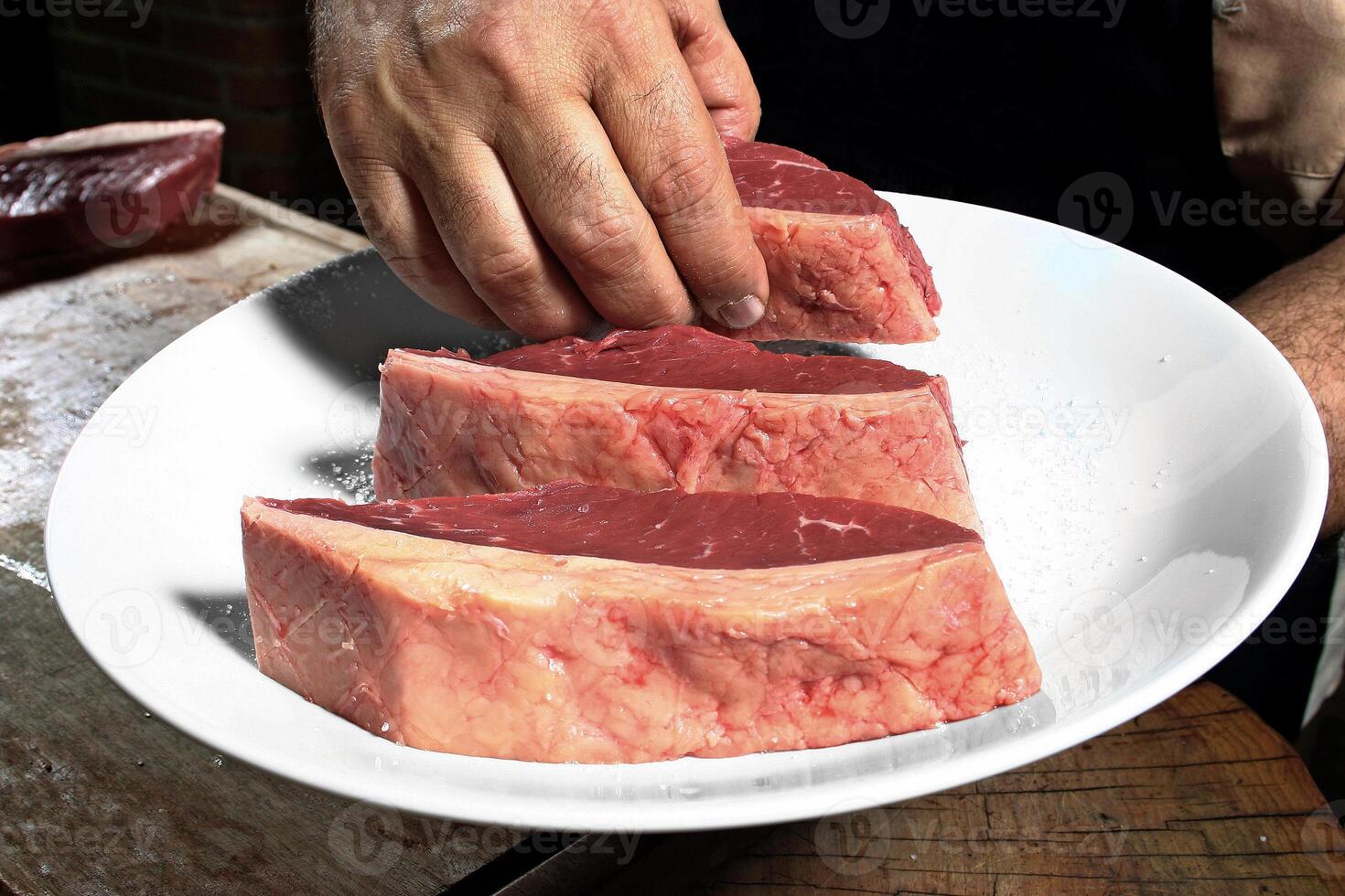 professional butcher teaching step by step how to prepare picanha, a Brazilian cut of meat photo
