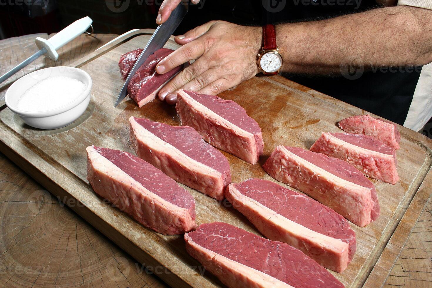 professional butcher teaching step by step how to prepare picanha, a Brazilian cut of meat photo